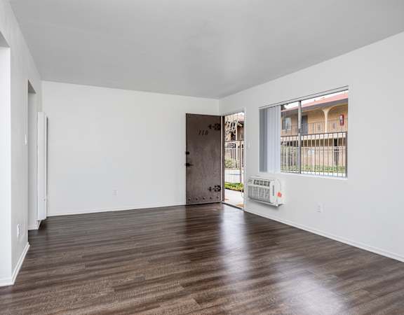 a bedroom with hardwood floors and white walls