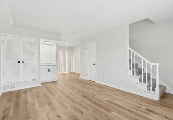 A room with a staircase and a cabinet.