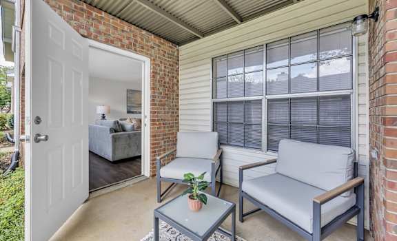 A small patio with a grey couch and a coffee table.