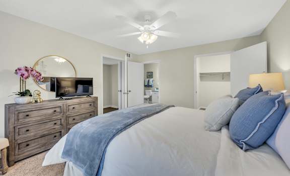 A bedroom with a bed, dresser, and mirror.