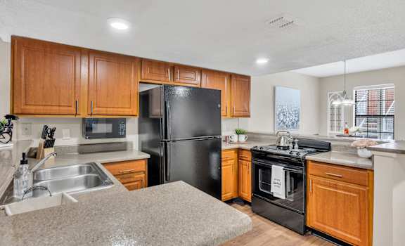 a kitchen with black appliances and wooden cabinets