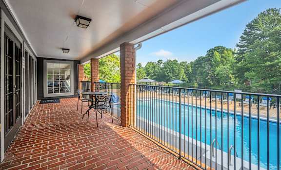 the view of the pool from the balcony of a house with a swimming pool