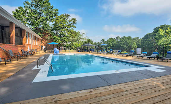 a swimming pool in front of a brick building with a resort style pool