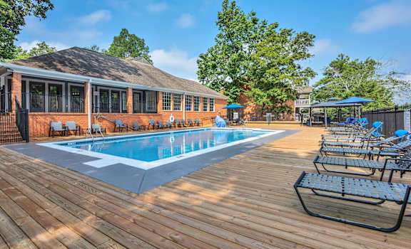 a swimming pool with chairs around it outside of a building