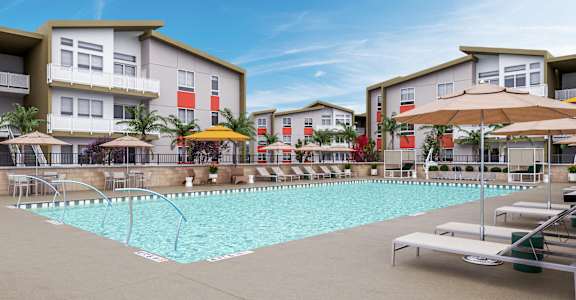 a swimming pool in front of a row of apartment buildings