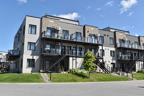 A modern apartment building with balconies and staircases.