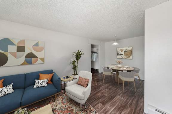 A living room with a blue couch and a white chair.