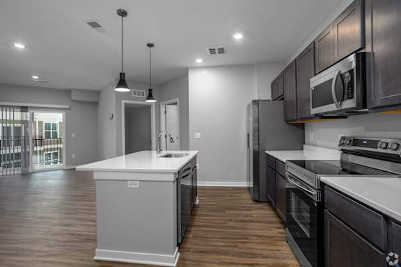 A modern kitchen with dark wood cabinets and white countertops.