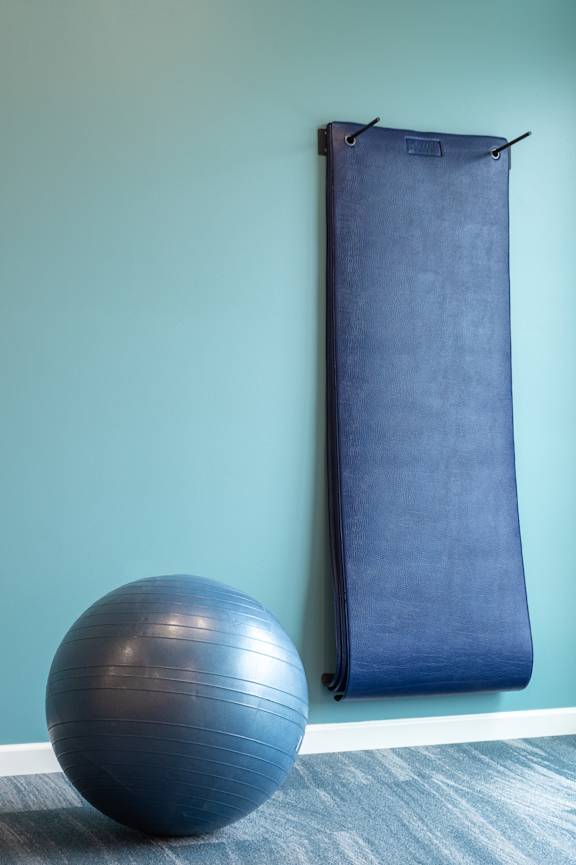 an exercise ball in the corner of a room next to a blue curtain