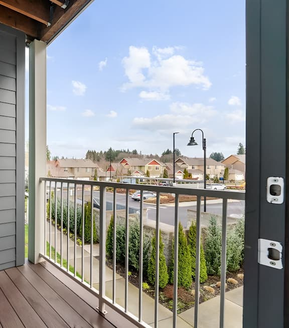 A black door is on the left side of a balcony.