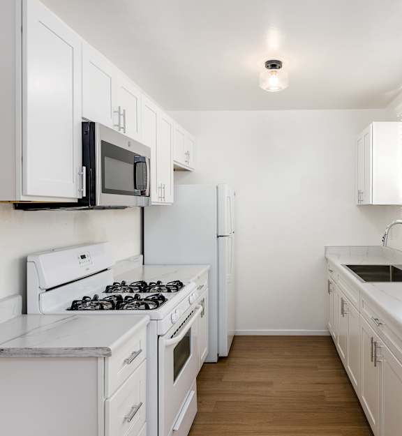 a kitchen with white cabinets and a black stove