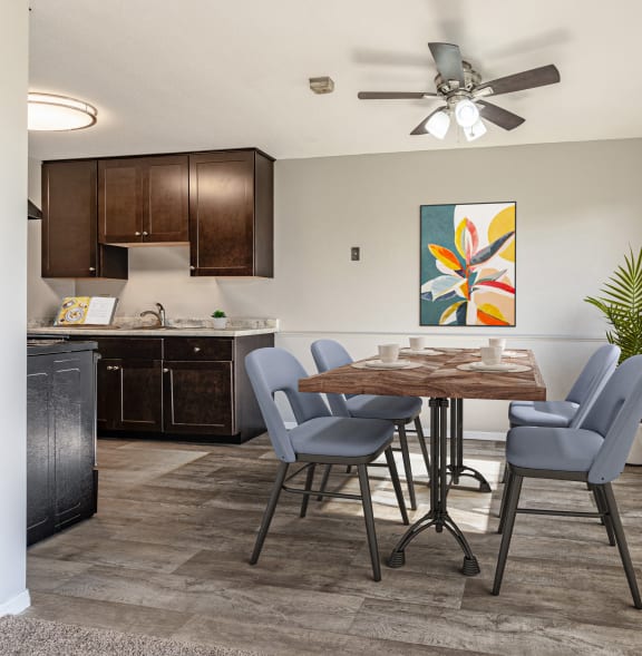 an open kitchen and dining room with a table and chairs and a ceiling fan