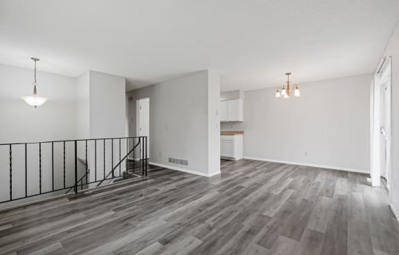 the living room and dining room of an apartment with wood flooring