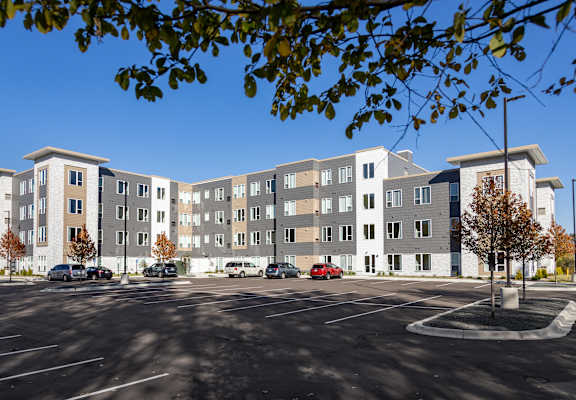 a large apartment building with cars parked in a parking lot