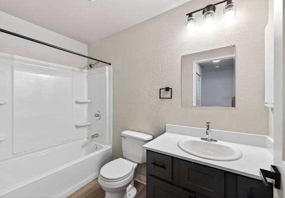 A white bathroom with a toilet, sink, and bathtub.
