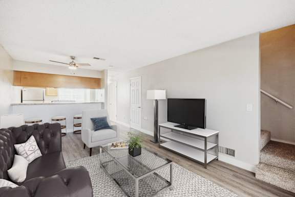 A living room with a grey couch and a glass coffee table.