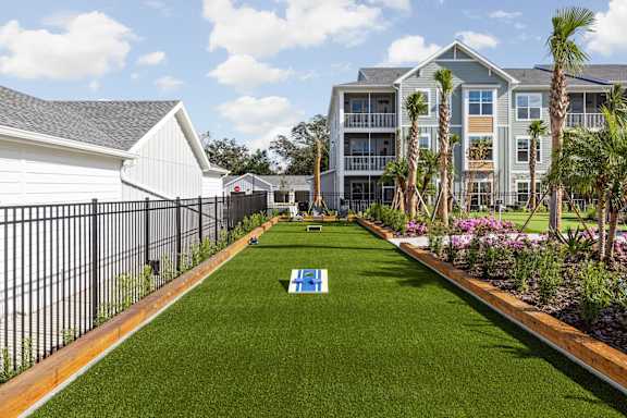 A grassy area with cornhole game in the middle at Standard441 Luxury Apartment Homes, Lady Lake, FL, 32159