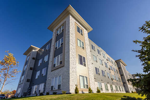an apartment building on a hill with a blue sky