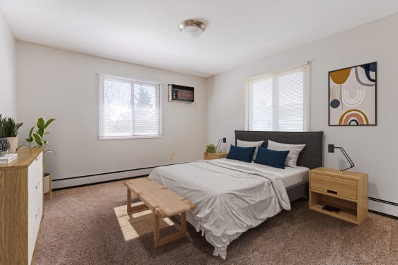 a bedroom with a bed and a dresser and two windows