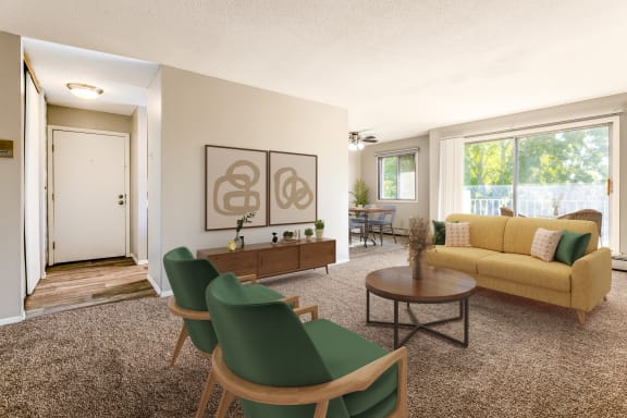 a living room with a yellow couch and green chairs