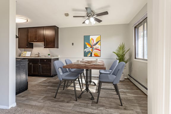an open kitchen and dining room with a table and chairs and a ceiling fan