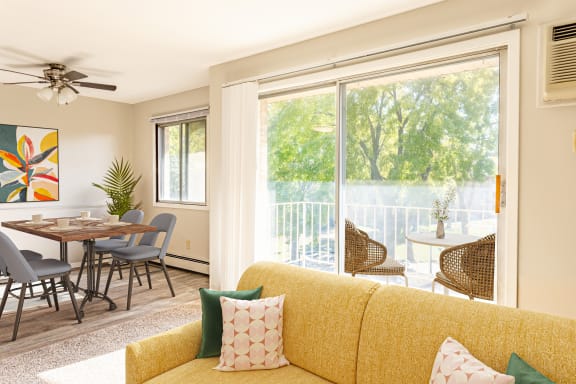 a living room with a yellow couch and a table with chairs