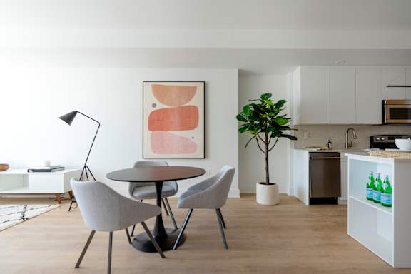 A modern dining room with a round table and chairs.at 929 Richmond Apartments, Ottawa, K2B 6R1