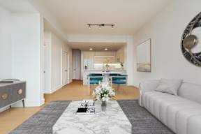 A modern living room with a white sofa and a grey coffee table.