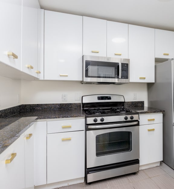 a kitchen with white cabinets and granite countertops