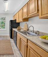 A kitchen with black appliances and wooden cabinets.
