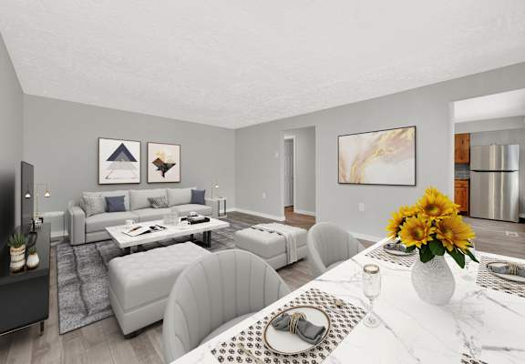 A modern living room with a grey sofa set and a white dining table set with a vase of sunflowers.