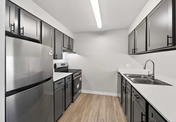 A modern kitchen with stainless steel appliances and black cabinets.
