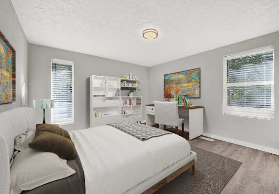 A bedroom with a bed, desk, and a painting on the wall.