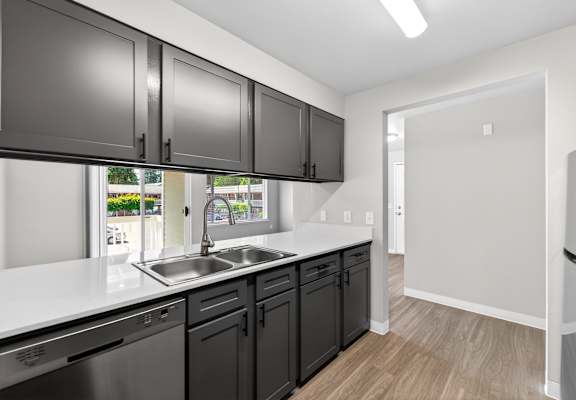 A kitchen with black cabinets and a white countertop.