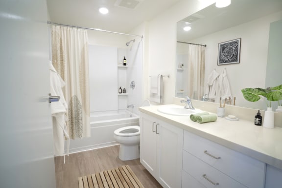 a white bathroom with a shower and a sink and a toilet