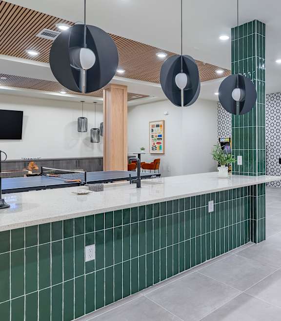 A modern kitchen with green tiled backsplash and a grey countertop at The Collective Upper Westside Apartments, Atlanta, GA, 30318