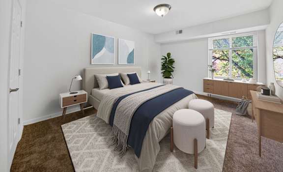 A bedroom with a large bed and a window overlooking trees.