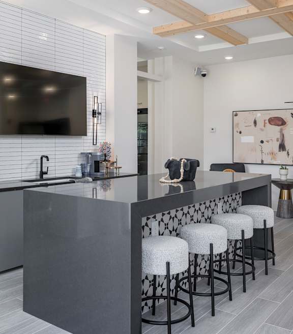 A modern kitchen with a bar area and stools at The Collective Upper Westside Apartments, Atlanta, GA, 30318