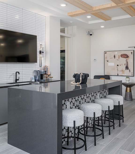 A modern kitchen with a bar area and stools at The Collective Upper Westside Apartments, Atlanta, GA, 30318