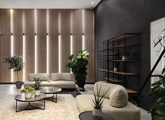 A living room with a green armchair and a white sofa.