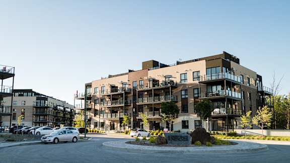 A modern apartment complex with a parking lot in front.