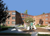 Thumbnail 4 of 4 - a large brick building with a playground in front of it