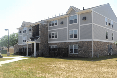 a large apartment building with a yard in front of it