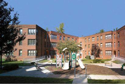 a large brick building with a playground in front of it
