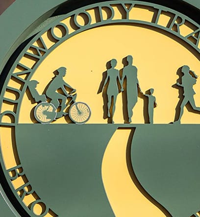 A sign with a family silhouette and a person on a bicycle.