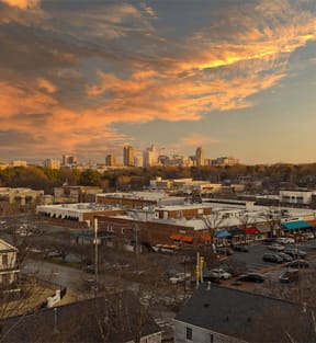 the city skyline at sunset with a cloudy sky and a parking lot