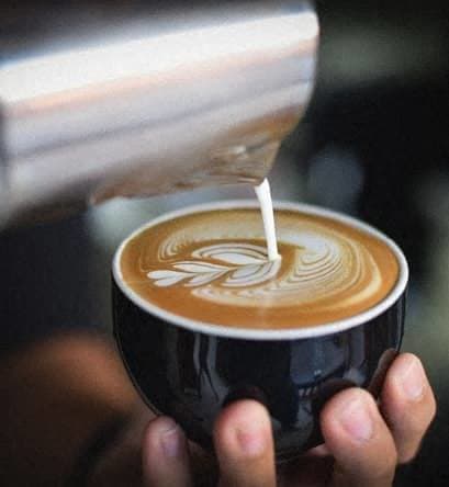 a person is holding a cup of coffee at Whitcomb Terrace Apartments, Merrillville, IN, 46410