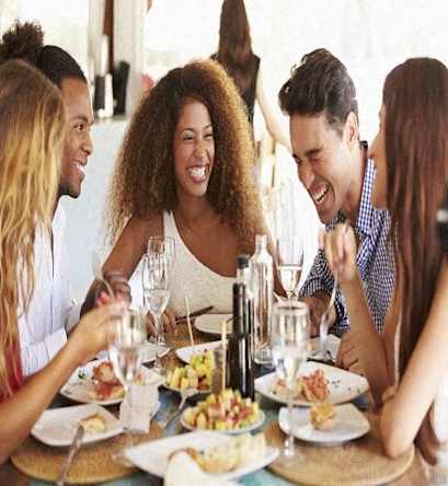a group of people sitting around a table eating food