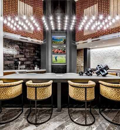 A bar with four stools and a brick wall in the background.