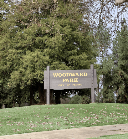 Green grass surrounding woodward park sign, Park Ridge Apartments, Fresno, CA